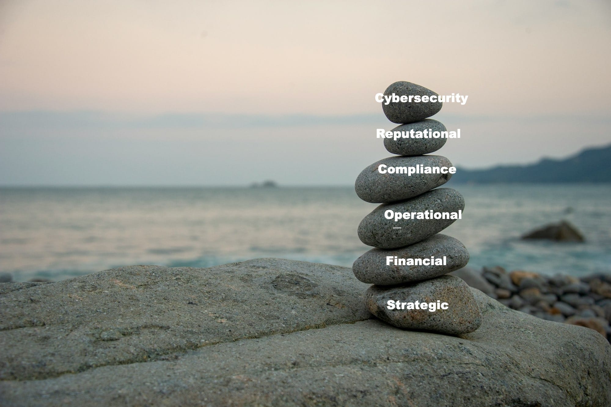 a stack of rocks sitting on top of a rock near the ocean